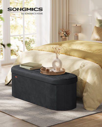 SONGMICS MAZIE Collection - Folding Ottoman with Storage, Oval Storage Ottoman Bench, End of Bed Bench, Velvet Fabric, 15 x 43 x 15 Inches, Ink Black
